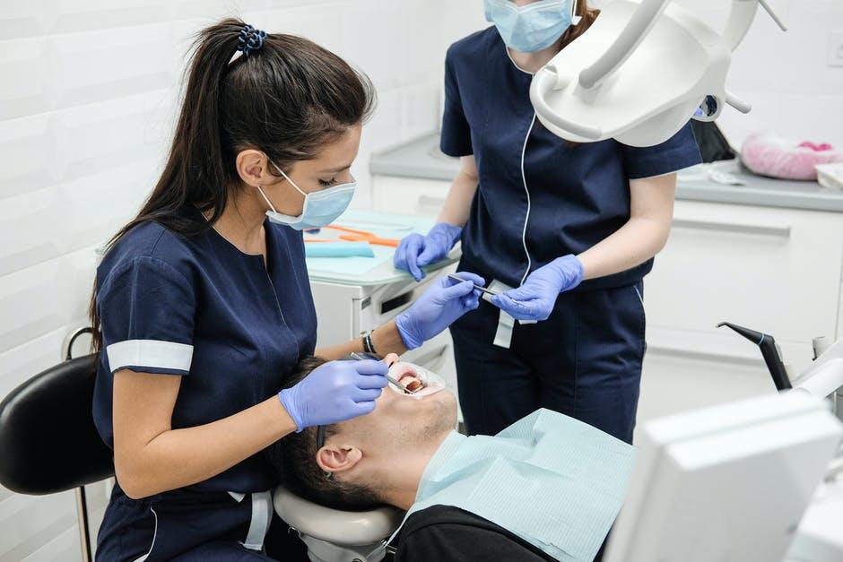 Dental professionals performing a procedure on a patient in a clinic