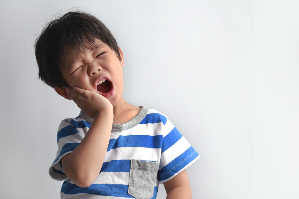 Child wearing a blue and white striped t-shirt with a gray pocket standing against a light background.